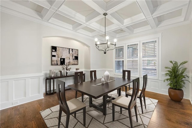 dining space with a chandelier, beam ceiling, coffered ceiling, and wood finished floors