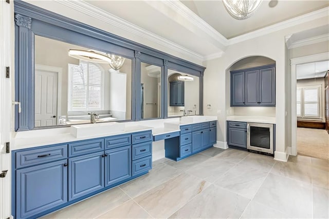 bathroom with baseboards, vanity, beverage cooler, and crown molding