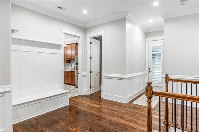 corridor featuring dark wood finished floors, visible vents, recessed lighting, and ornamental molding