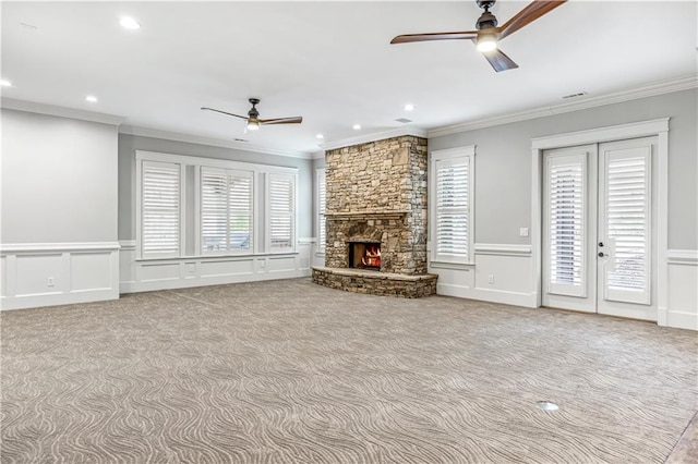 unfurnished living room featuring crown molding, a fireplace, and a decorative wall