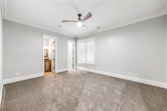 unfurnished bedroom with visible vents, baseboards, ornamental molding, carpet flooring, and ensuite bath