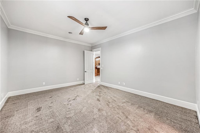 carpeted spare room with baseboards, ceiling fan, and ornamental molding