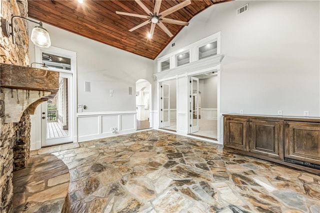 unfurnished room with visible vents, arched walkways, ceiling fan, wood ceiling, and wainscoting