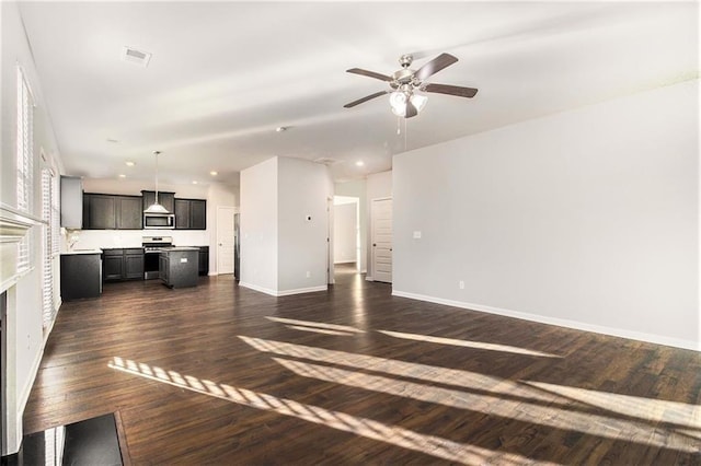 unfurnished living room featuring ceiling fan and dark hardwood / wood-style flooring