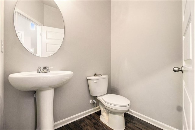 bathroom with toilet and hardwood / wood-style floors