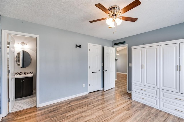 unfurnished bedroom featuring light wood-type flooring, baseboards, and a textured ceiling