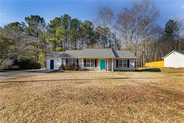 ranch-style home featuring fence and a front lawn