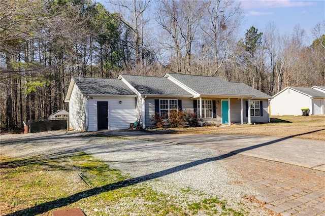 single story home featuring a porch and decorative driveway