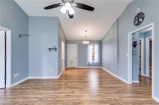 foyer entrance featuring vaulted ceiling, ceiling fan, baseboards, and light wood-style floors