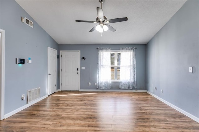 interior space featuring light wood-style floors, ceiling fan, and visible vents