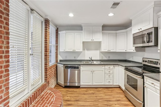 869 Briarcliff Rd NE Unit B25, Atlanta, GA 30306 - kitchen with stainless steel appliances, a sink, visible vents, white cabinets, and light wood-type flooring