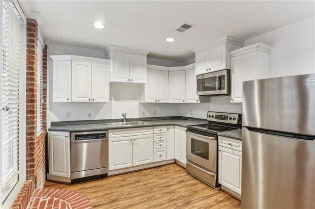 869 Briarcliff Rd NE Unit B25, Atlanta, GA 30306 - kitchen featuring appliances with stainless steel finishes, dark countertops, white cabinets, and a sink