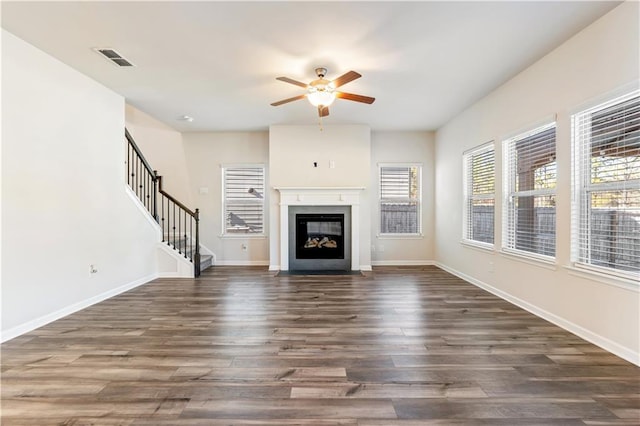 unfurnished living room with dark wood-type flooring and ceiling fan