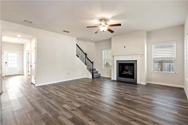 unfurnished living room featuring ceiling fan and dark hardwood / wood-style flooring