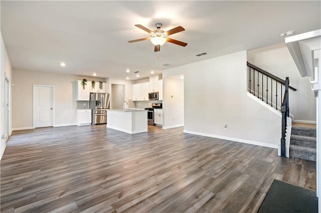 unfurnished living room featuring ceiling fan, dark hardwood / wood-style flooring, and sink