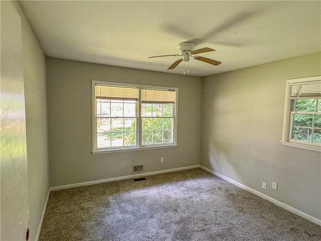 carpeted spare room featuring ceiling fan