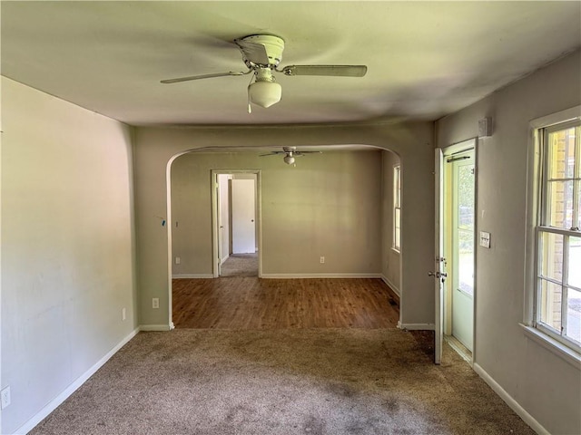 carpeted empty room featuring ceiling fan and plenty of natural light