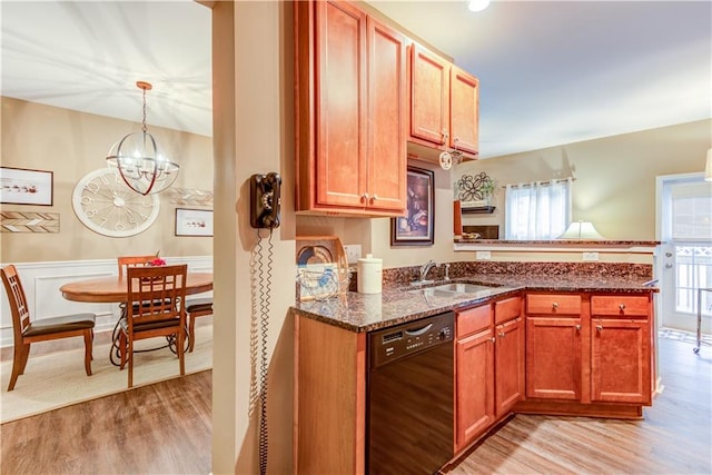 kitchen with black dishwasher, light hardwood / wood-style floors, a chandelier, decorative light fixtures, and dark stone countertops