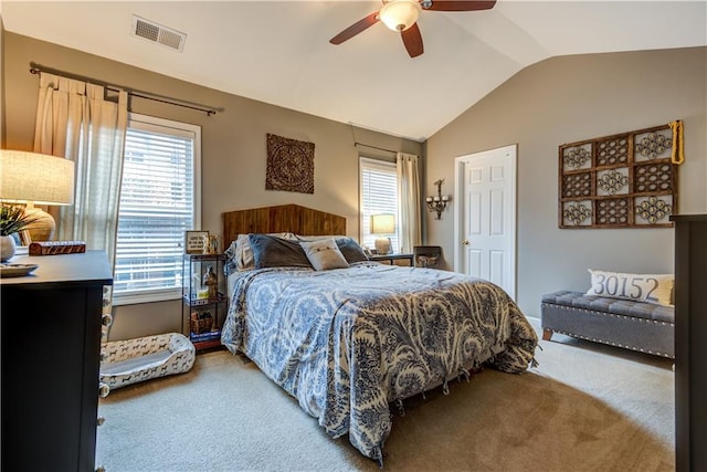 carpeted bedroom with ceiling fan, vaulted ceiling, and multiple windows