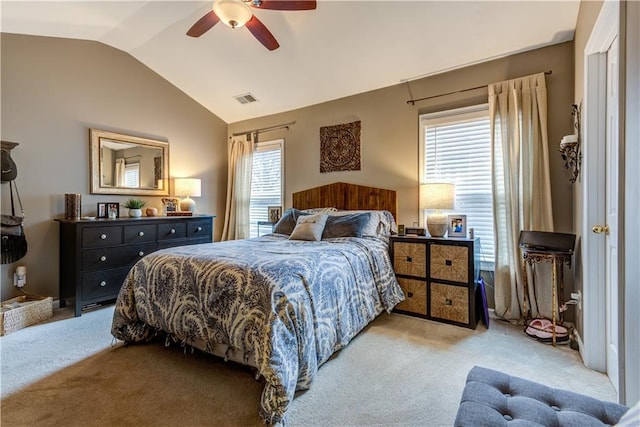bedroom featuring ceiling fan, vaulted ceiling, visible vents, and light colored carpet