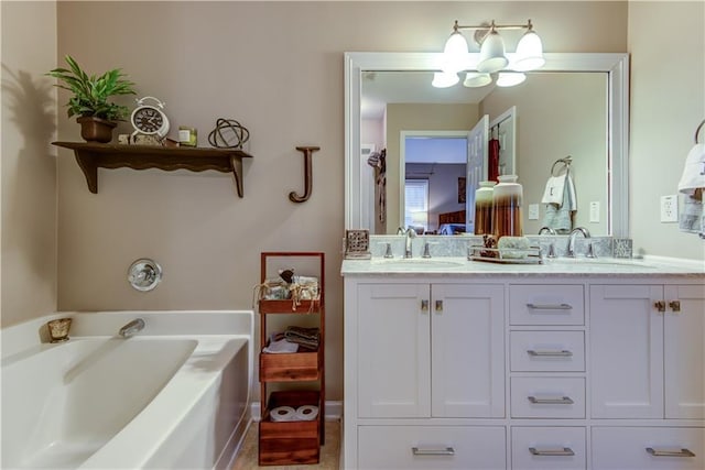 ensuite bathroom featuring double vanity, a sink, ensuite bath, a chandelier, and a garden tub