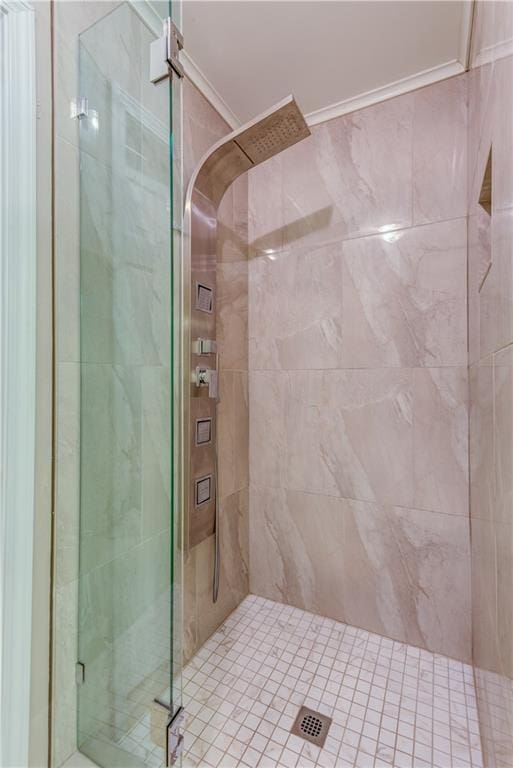 bathroom with ornamental molding and a shower with shower door