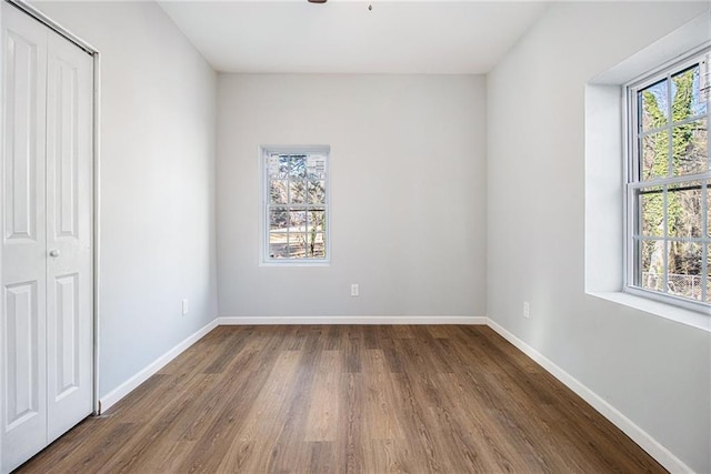 unfurnished bedroom with dark hardwood / wood-style flooring and a closet