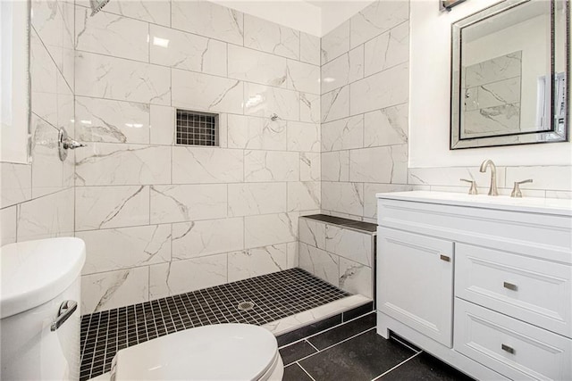 bathroom featuring tiled shower, vanity, toilet, and tile walls