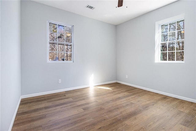 unfurnished room featuring ceiling fan, plenty of natural light, and wood-type flooring