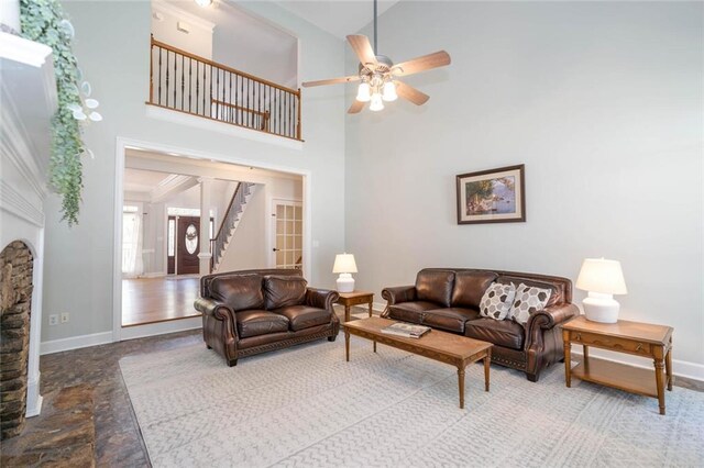 living room with ceiling fan and a high ceiling