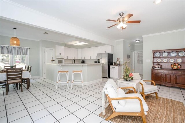 kitchen with white cabinetry, stainless steel refrigerator with ice dispenser, kitchen peninsula, crown molding, and decorative light fixtures