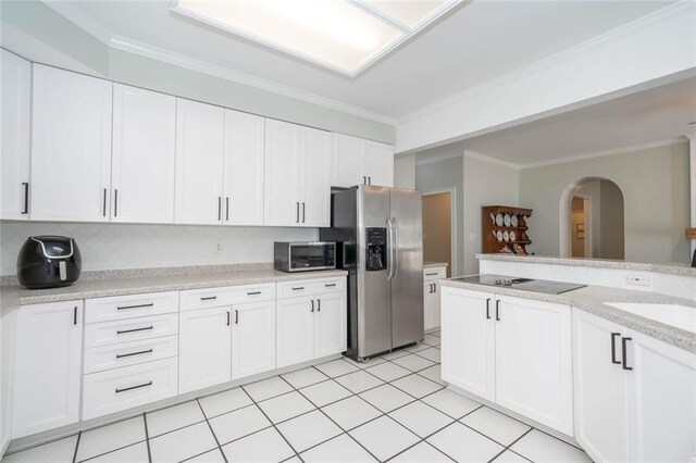 kitchen with white cabinetry, crown molding, stainless steel appliances, and light stone counters