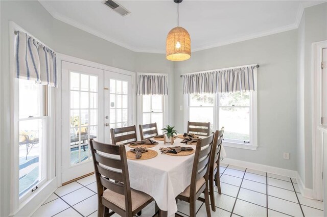 dining area with light tile patterned flooring, ornamental molding, and a wealth of natural light