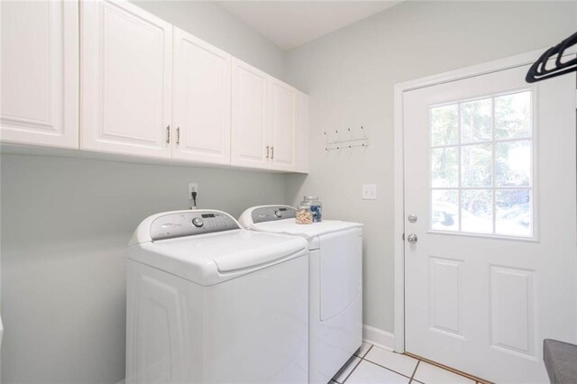 washroom with separate washer and dryer, light tile patterned floors, and cabinets