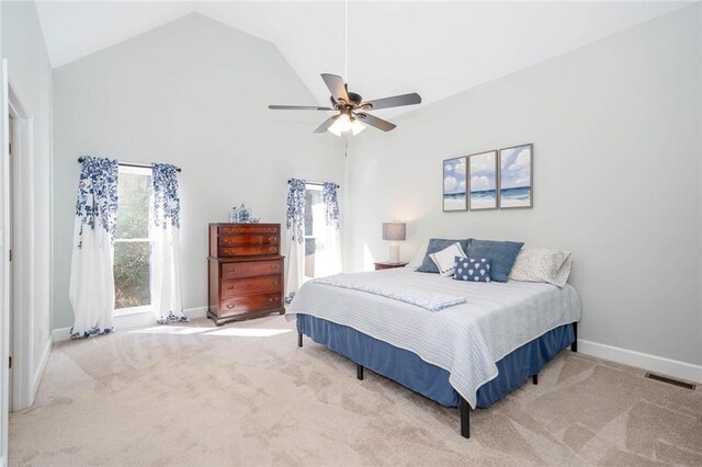 bedroom featuring ceiling fan, light colored carpet, and high vaulted ceiling