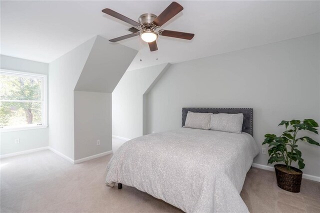 bedroom featuring ceiling fan, light colored carpet, and vaulted ceiling