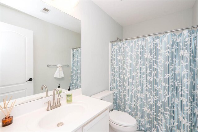 bathroom with a shower with curtain, vanity, and toilet