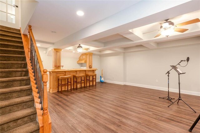 basement with hardwood / wood-style floors, ceiling fan, and indoor bar