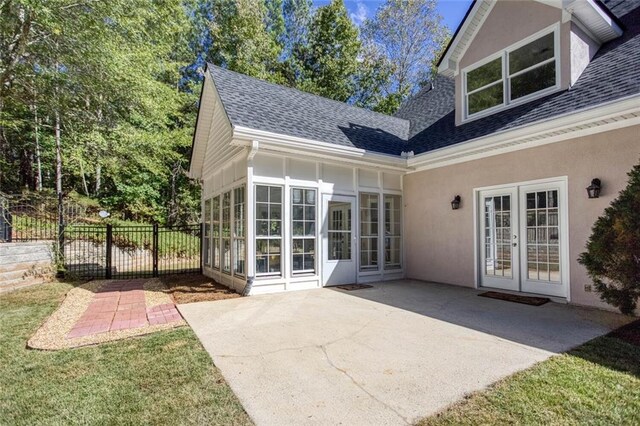 rear view of house featuring a yard, a patio area, a sunroom, and french doors