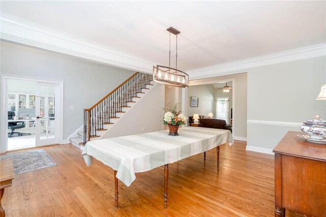 dining area featuring light wood-type flooring, ceiling fan, and ornamental molding