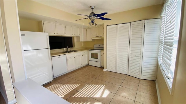 kitchen featuring white cabinetry, sink, light tile patterned floors, and white appliances