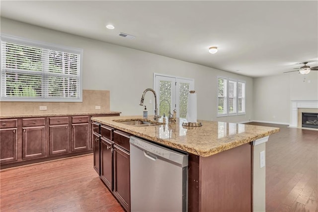 1354 Slate Bend Dr, Dacula, GA 30019 - kitchen with light hardwood / wood-style floors, a kitchen island with sink, stainless steel dishwasher, sink, and backsplash