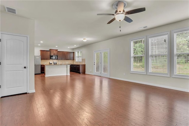 unfurnished living room with dark hardwood / wood-style floors and ceiling fan