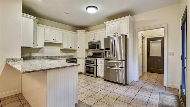 kitchen featuring appliances with stainless steel finishes, a peninsula, light tile patterned floors, and white cabinetry