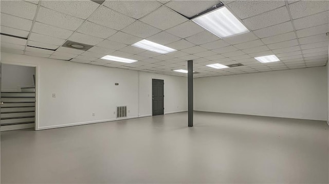 basement with stairway and a paneled ceiling