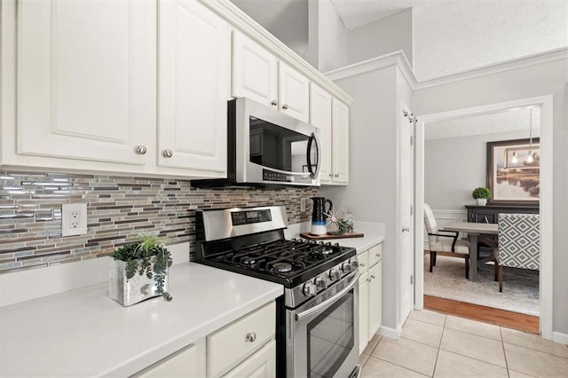 kitchen featuring appliances with stainless steel finishes, light tile patterned floors, light countertops, and white cabinetry