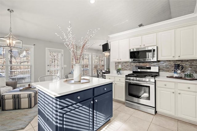 kitchen with pendant lighting, stainless steel appliances, light countertops, and white cabinets