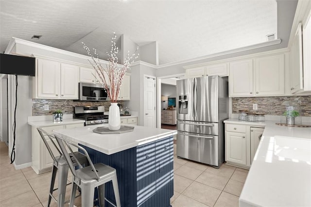 kitchen with stainless steel appliances, light tile patterned flooring, light countertops, and white cabinets