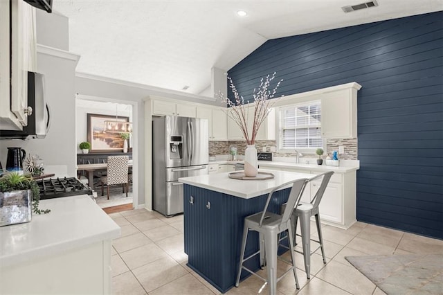 kitchen featuring appliances with stainless steel finishes, light countertops, a kitchen island, and white cabinetry