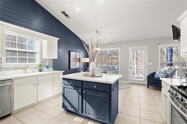 kitchen with light countertops, visible vents, appliances with stainless steel finishes, white cabinets, and a kitchen island